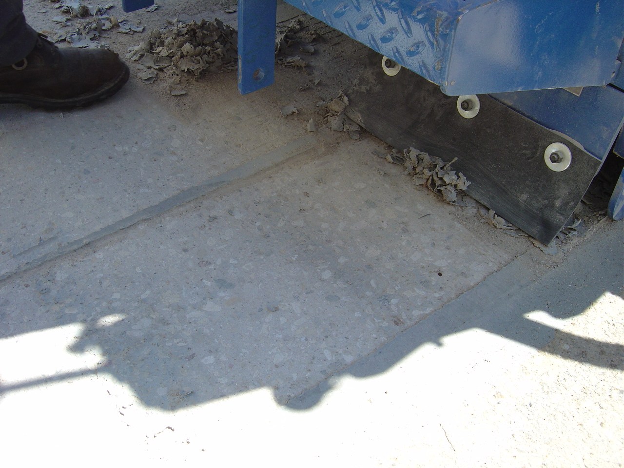 Milling equipment removing coating from concrete
